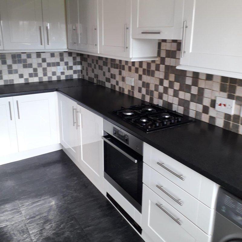 Dark kitchen floor paired with white fitted cabinets
